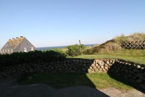 a stone wall in front of a house and a building at Hüs Auert Tharep, Wohnung 5 in Hörnum