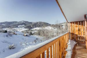 um deque com vista para as montanhas cobertas de neve em Le Refuge des Anges em Megève