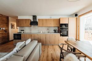 uma cozinha com um sofá e uma mesa num quarto em Le Refuge des Anges em Megève