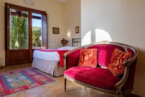 um quarto com uma cama, uma cadeira e uma janela em B&B Villa Giulia em Saturnia