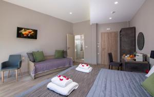 a living room with a couch and two white towels at Stoa Suites Chania in Chania Town