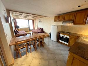 a kitchen with a wooden table and a dining room at Résidence Le Portillo in Val Thorens