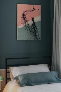 a bedroom with a bed and a painting on the wall at Atelier Boutique Hotel in Shkodër