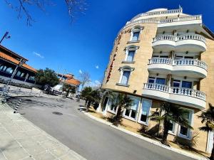 un grande edificio bianco con balconi su strada di Family Hotel Paros a Pomorie