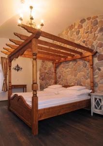 een slaapkamer met een houten bed in een stenen muur bij Régi Posta Étterem és Fogadó in Debrecen