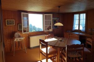 - une salle à manger avec une table, des chaises et des fenêtres dans l'établissement Bauernhaus mit Charme, Traumaussicht und Sauna, à Weggis