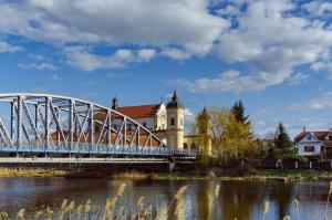 eine Brücke über einen Fluss vor einem Gebäude in der Unterkunft Przystanek Tykocin - apartamenty gościnne in Tykocin