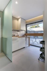 a kitchen with white cabinets and a large window at Pateo 780 in Vila Nova de Gaia