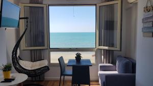 - un salon doté d'une fenêtre offrant une vue sur la plage dans l'établissement Arteg Apartments - Full Sea View, à Durrës