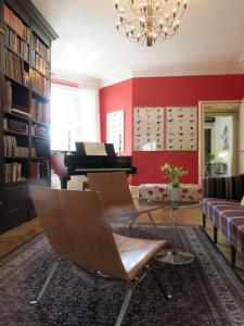 ein Wohnzimmer mit roten Wänden und einem Klavier in der Unterkunft ApartmentInCopenhagen Apartment 1290 in Kopenhagen