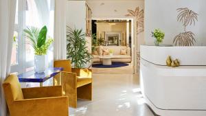 a living room with gold chairs and a table at The Beverly Hills Hotel - Dorchester Collection in Los Angeles