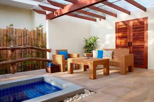 une terrasse avec une table, des chaises et une piscine dans l'établissement Bluewater Sumilon Island Resort, à Sumilon Island