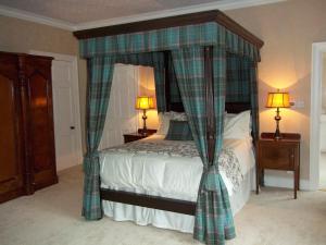 - une chambre avec un lit à baldaquin dans l'établissement Carnach House, à Nairn