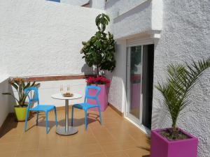 uma varanda com mesa, cadeiras e plantas em Hotel Alexandra Sitges em Sitges