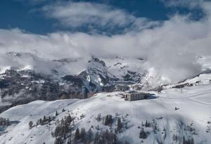 een gebouw bovenop een met sneeuw bedekte berg bij chetzeron in Crans-Montana