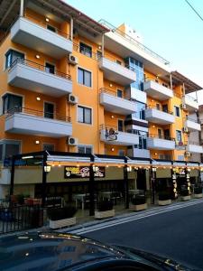 um grande edifício de apartamentos com um restaurante em frente em Aparthotel Shkodra em Durrës