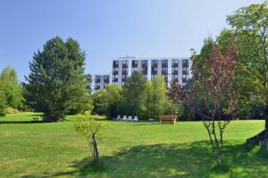 un parque con un banco y un edificio al fondo en Hotel Kaiseralm, en Bischofsgrün