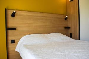 A bed or beds in a room at Premiere Classe Rodez