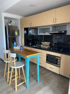 une cuisine avec une table bleue et deux chaises dans l'établissement Apto 307 Metroloft Armenia, à Armenia