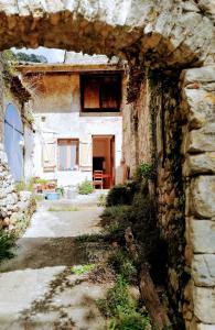 un antiguo edificio de piedra con una puerta abierta en Gite des Gorges de l'Ardèche, en Chame