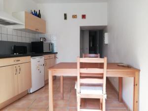 cocina con mesa de madera y silla en Gite des Gorges de l'Ardèche, en Chame