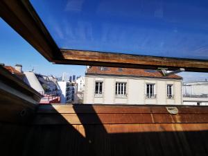 uma vista para um edifício a partir de uma janela sobre um telhado em Studio La Belle Vie em Suresnes