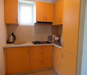 a kitchen with orange cabinets and a stove top oven at Apartmány Dalila in Rajecké Teplice