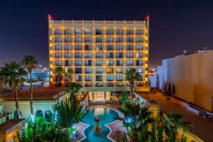 ein Hotel mit Pool und Palmen in der Nacht in der Unterkunft Hotel Lucerna Ciudad Juarez in Ciudad Juárez