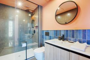 La salle de bains est pourvue de toilettes, d'un lavabo et d'un miroir. dans l'établissement Les Lofts Dorchester - Par Les Lofts Vieux-Québec, à Québec