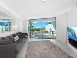 a living room with a couch and a flat screen tv at Sirocco 202 in Mooloolaba