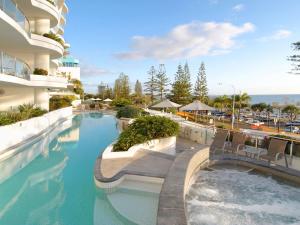 a swimming pool with chairs in a building at Sirocco 202 in Mooloolaba