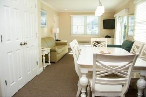 a kitchen and living room with a white table and chairs at InnSeason Resorts HarborWalk in Falmouth