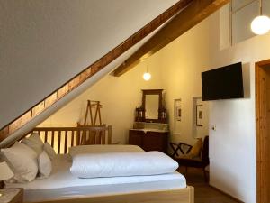 a bedroom with a white bed and a staircase at CALLM aka Zum goldenen Löwen - zu Nacht bei der Destillerie in Kallmünz