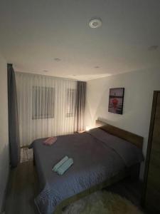 1 dormitorio con cama y ventana en LUNA Apartment, en Novi Pazar