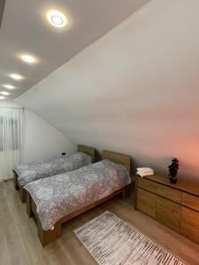 1 dormitorio con 2 camas y tocador de madera en LUNA Apartment, en Novi Pazar