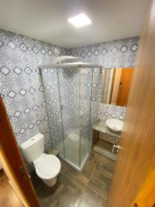 a bathroom with a toilet and a shower and a sink at Swell Praia Hotel in Natal