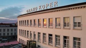 a building with a sign on top of it at Hotel Grand Koper in Koper