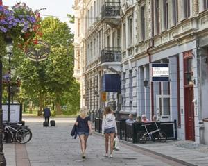 twee vrouwen die over een straat lopen in een stad bij Hotell Stadsparken in Helsingborg