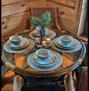 a glass table with blue and white dishes on it at Lāču namiņš/Bear house in Liepāja