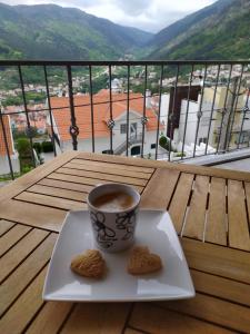 - une tasse de café et des biscuits sur une assiette dans l'établissement Casa Mariolas, à Manteigas