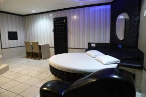 um quarto com uma cama e duas cadeiras pretas em Drops Motel Barretos em Barretos