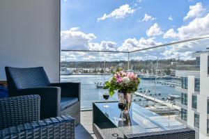 un balcone con tavolo in vetro e fiori di Apartament Faltom 20 Yacht Park Premium a Gdynia