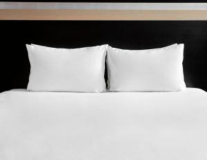 een wit bed met drie kussens erop bij Holiday Inn Bristol City Centre, an IHG Hotel in Bristol