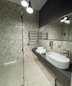 a bathroom with a sink and a glass shower at Apart-Hotel у центрі Трускавця in Truskavets