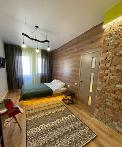 a bedroom with a bed and a brick wall at Apart-Hotel у центрі Трускавця in Truskavets