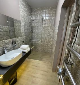 a bathroom with a sink and a shower at Apart-Hotel у центрі Трускавця in Truskavets