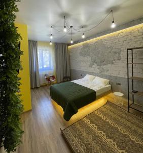 a bedroom with a bed and a brick wall at Apart-Hotel у центрі Трускавця in Truskavets