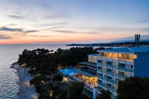 an aerial view of a hotel and the ocean at sunset at Hotel Pinija in Petrcane