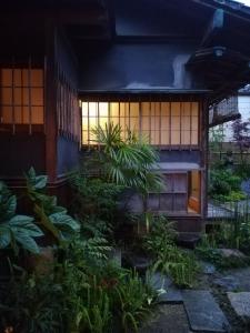 een gebouw met veel planten ervoor bij 旧鈴木邸 女性専用 in Matsuyama