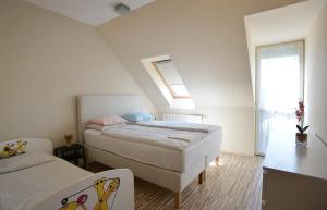 sypialnia z 2 łóżkami i oknem w obiekcie Family Deluxe Apartments w Egerze